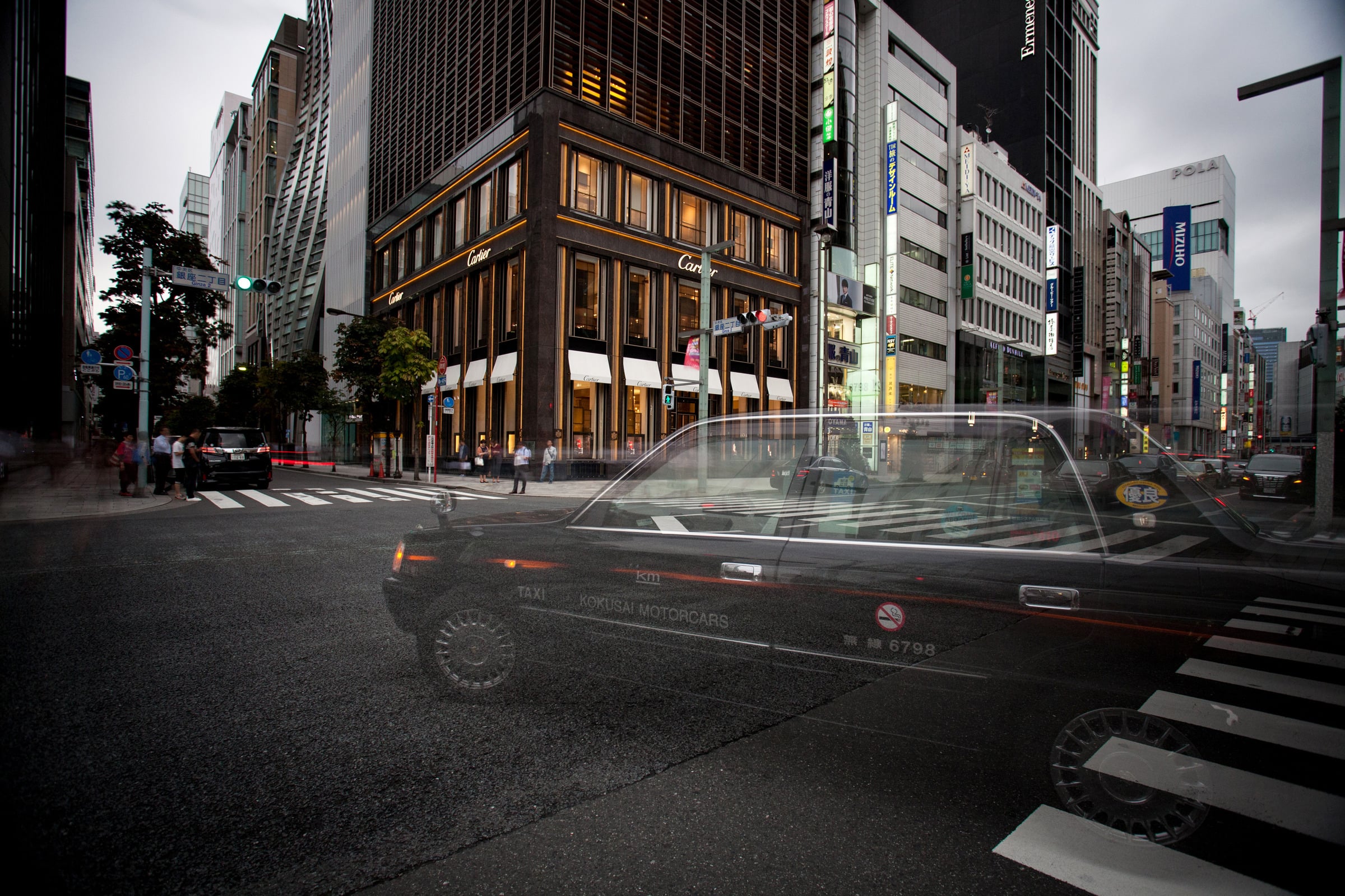Street corner with a taxi blurring past
